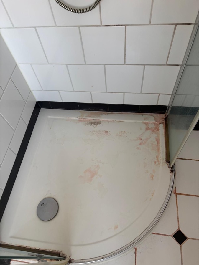Douchebak met kalk- en roestaanslag vóór de deepclean